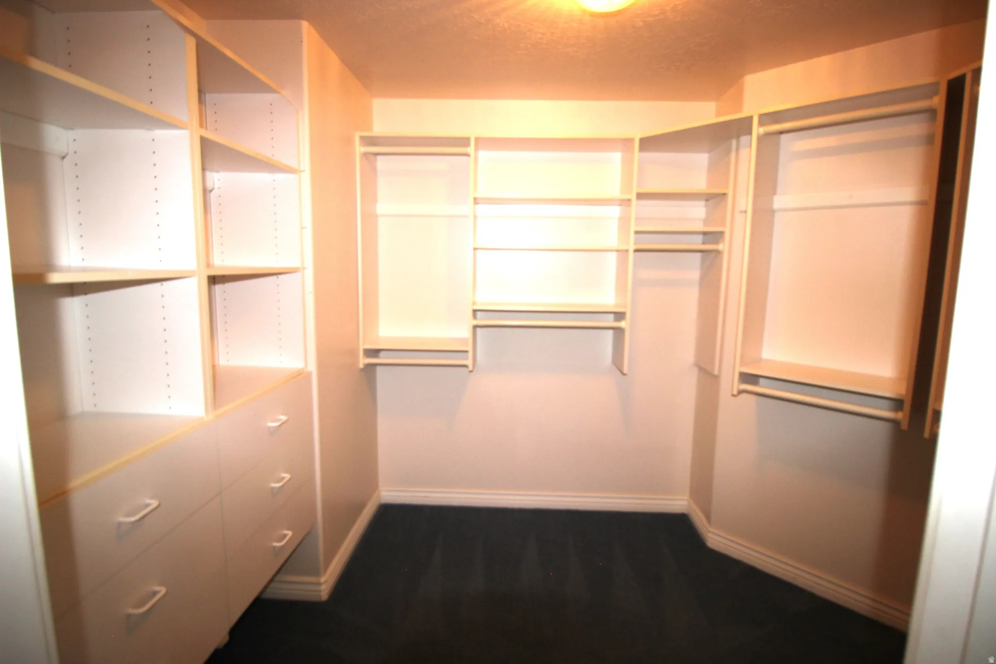 Master Bedroom Custom closet system featuring shelving, drawers, and hanging rods