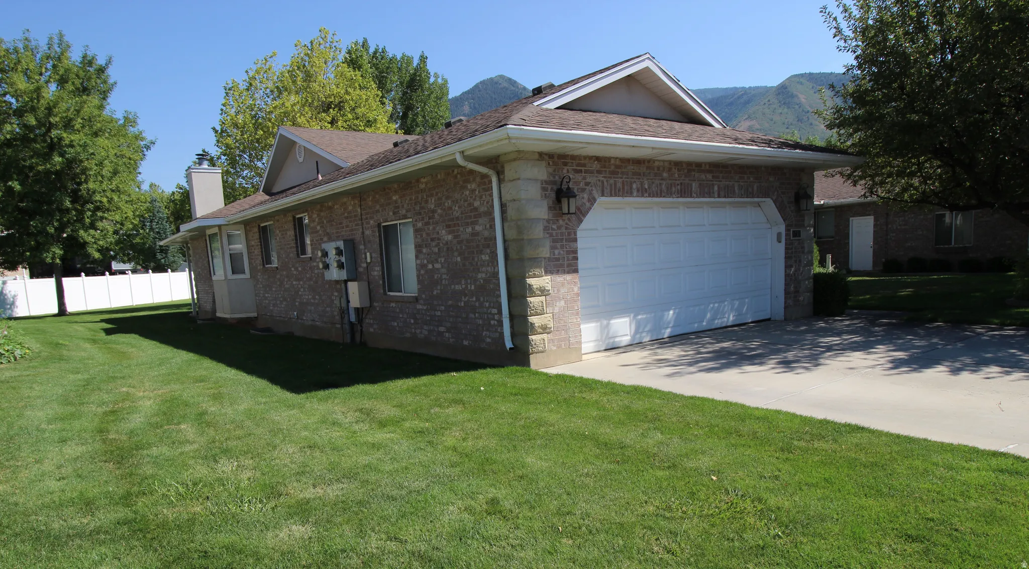 Brick exterior with stone veneer accents and an attached two-car garage