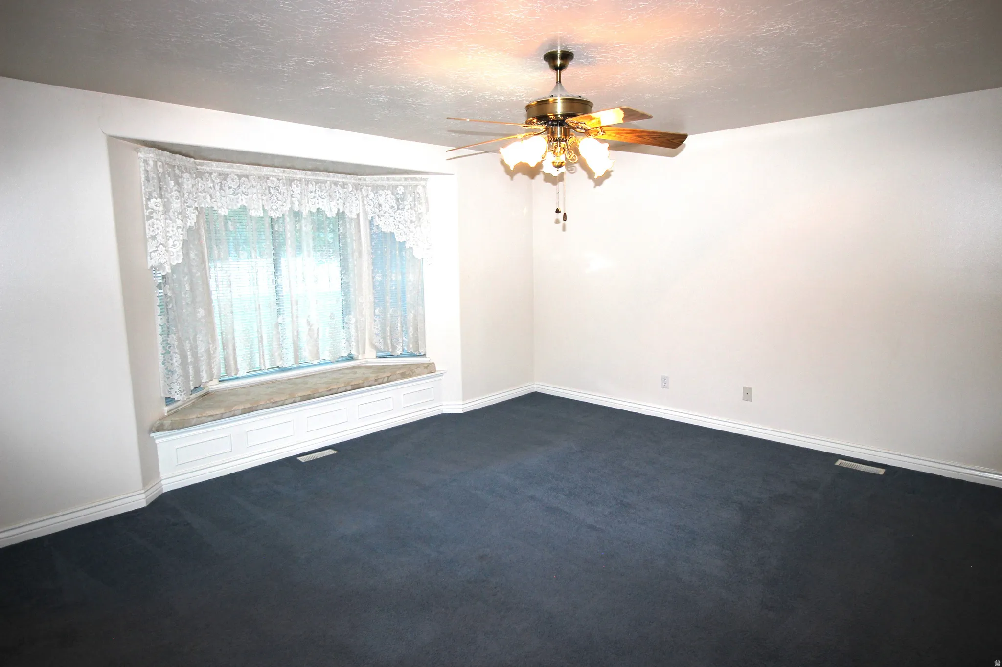 Master Bedroom with Recessed bay window with a built-in window seat, ceiling fan with integrated lighting, and wall-to-wall carpeting