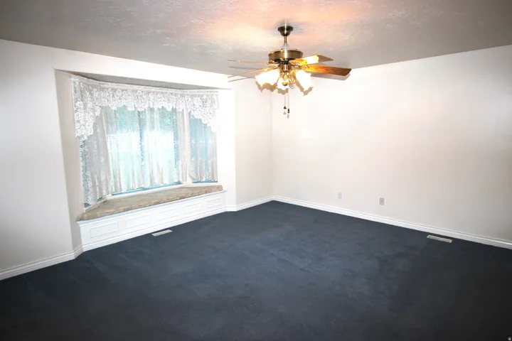 Master Bedroom with Recessed bay window with a built-in window seat, ceiling fan with integrated lighting, and wall-to-wall carpeting