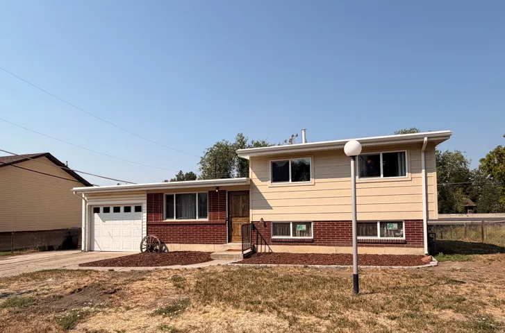 Split-level residence featuring a brick and siding exterior