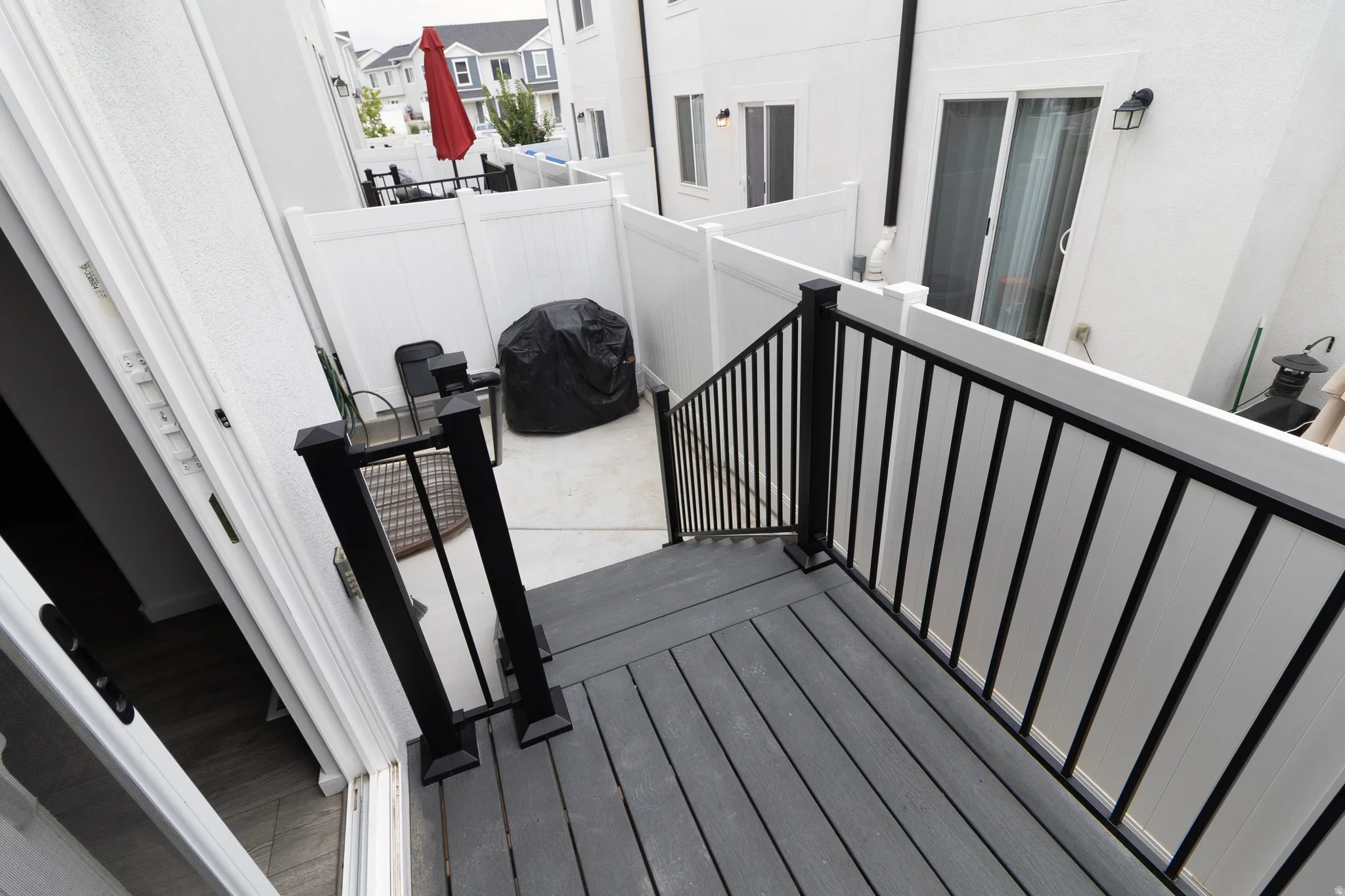 Exterior staircase with black railings  and fenced backyard