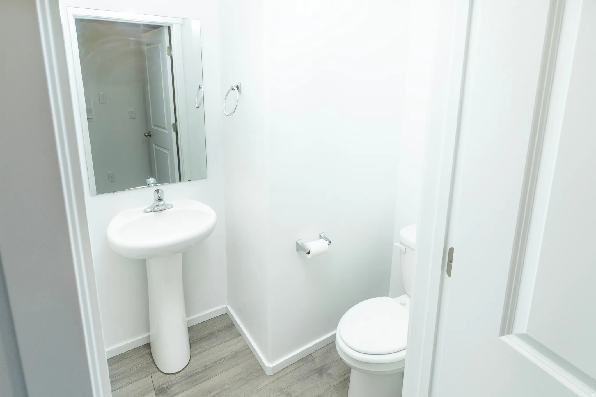 Pedestal sink with chrome faucet and rectangular mirror