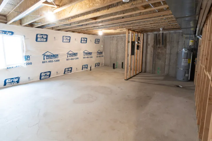 Unfinished basement with concrete flooring and exposed ceiling joists