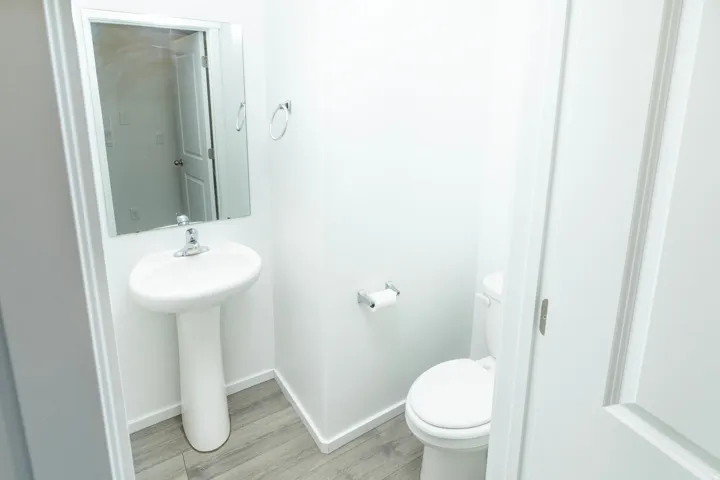 Pedestal sink with chrome faucet and rectangular mirror