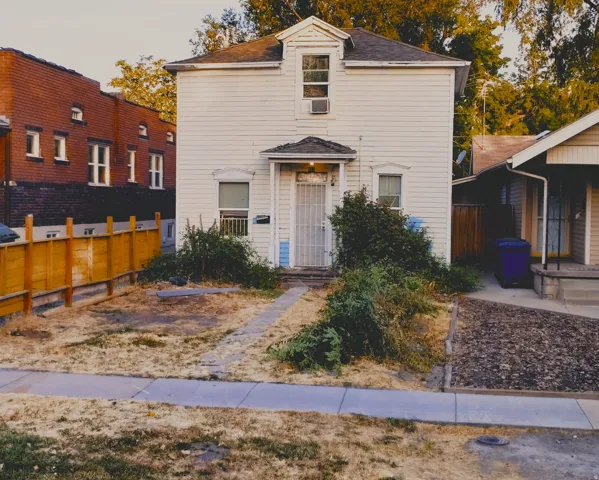 Two-story structure with white siding and a front-facing dormer