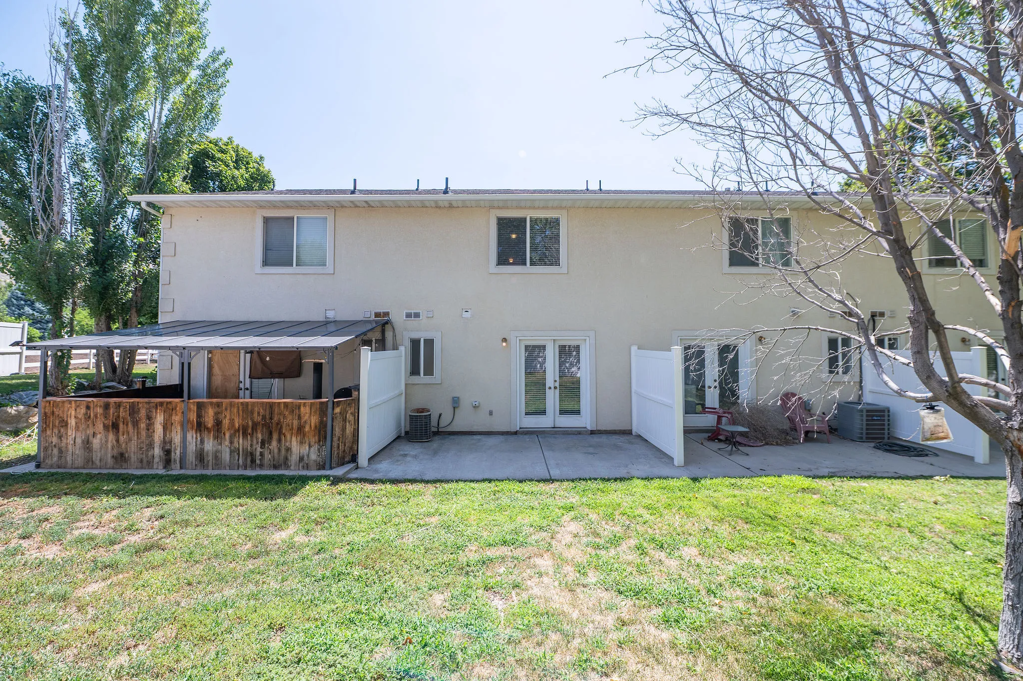 Rear exterior featuring private patio and double French doors