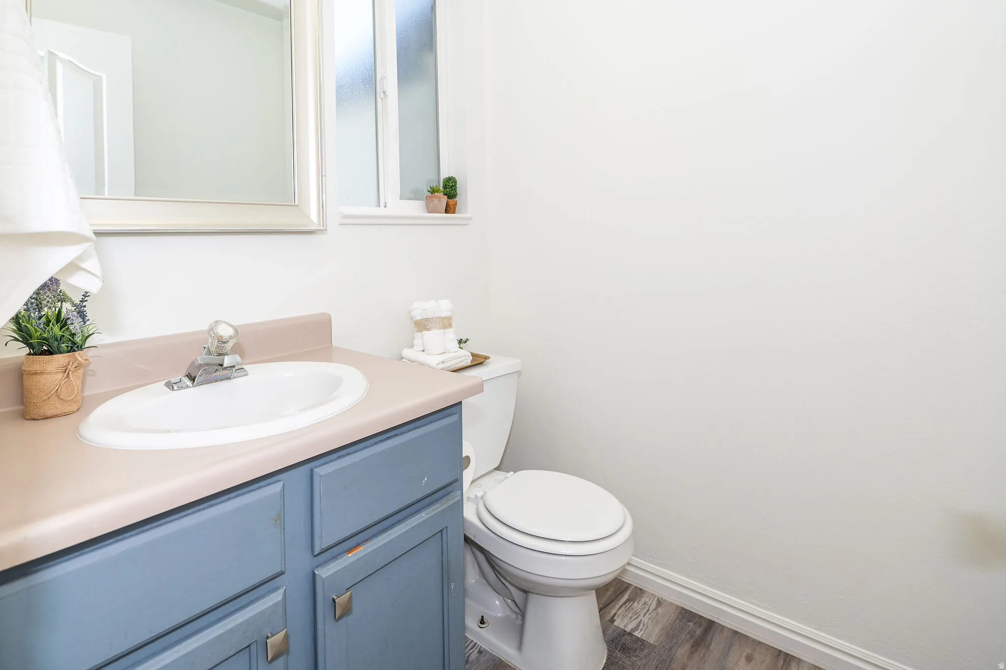 Half-bath located off of the dining area. Painted cabinets and LVP flooring.