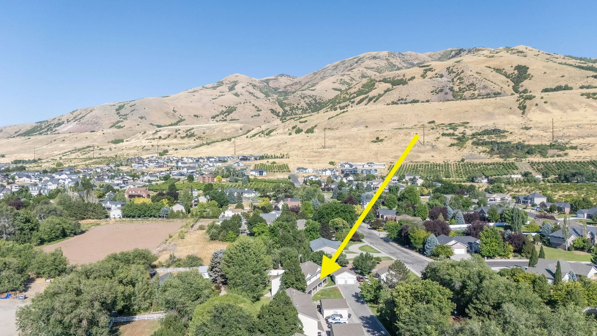 Residential property situated in a developed community with established trees, offering mountain scenery