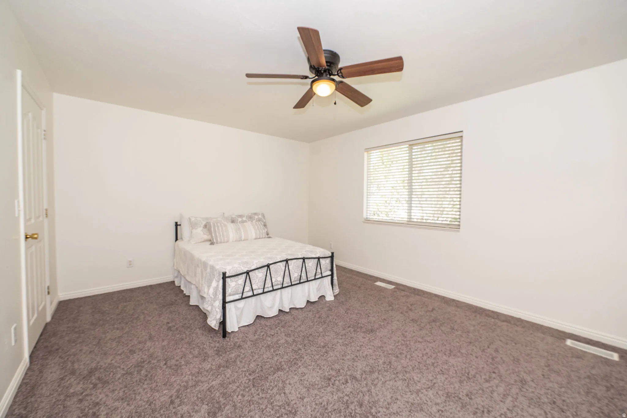 Spacious room featuring neutral carpeting and white walls