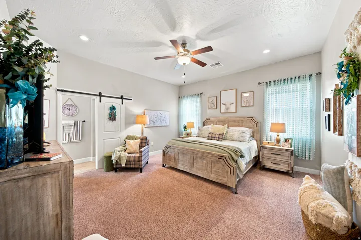 Spacious room featuring vaulted ceilings, recessed lighting, a ceiling fan, and light-colored carpeting