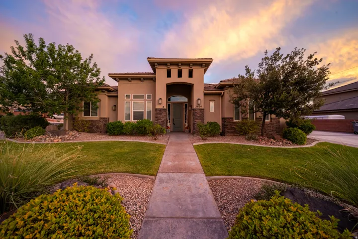Stucco exterior featuring stacked stone accents and a columned entry
