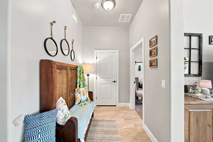 Hallway featuring tile flooring, white baseboards, and neutral wall paint