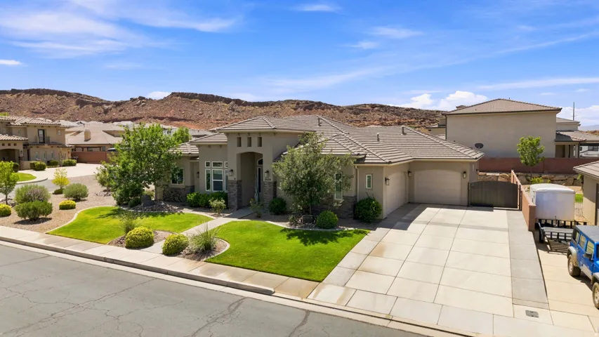 Contemporary stucco exterior with stone accents and a concrete tile roof