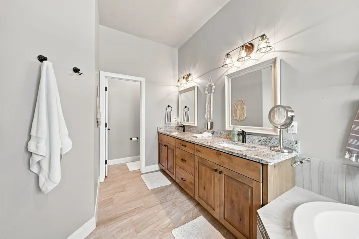 Double vanity with wood-finish cabinetry and granite countertops