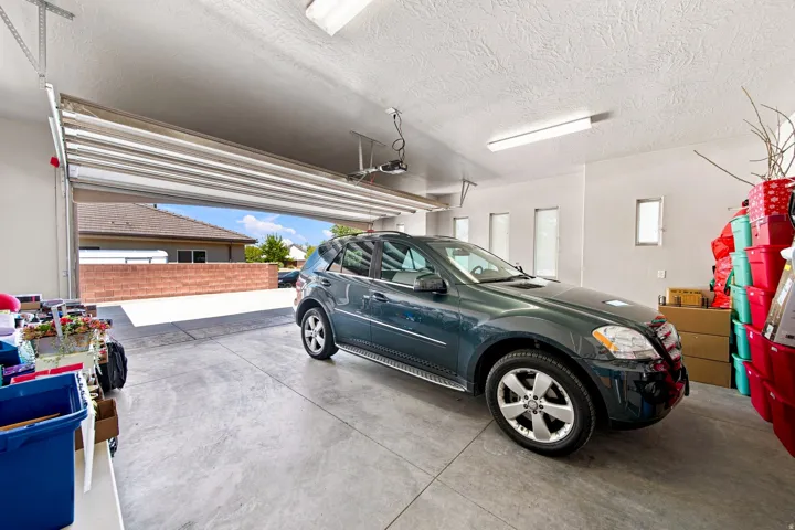 Spacious garage with an open overhead door, concrete flooring, recessed lighting, and multiple wall-mounted windows