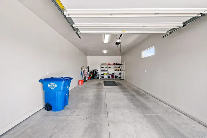 Spacious garage with a concrete floor, overhead lighting, and a high-level horizontal window