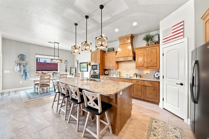 Spacious kitchen featuring a large island with seating, ample wood cabinetry, light-toned countertops, and a built-in microwave