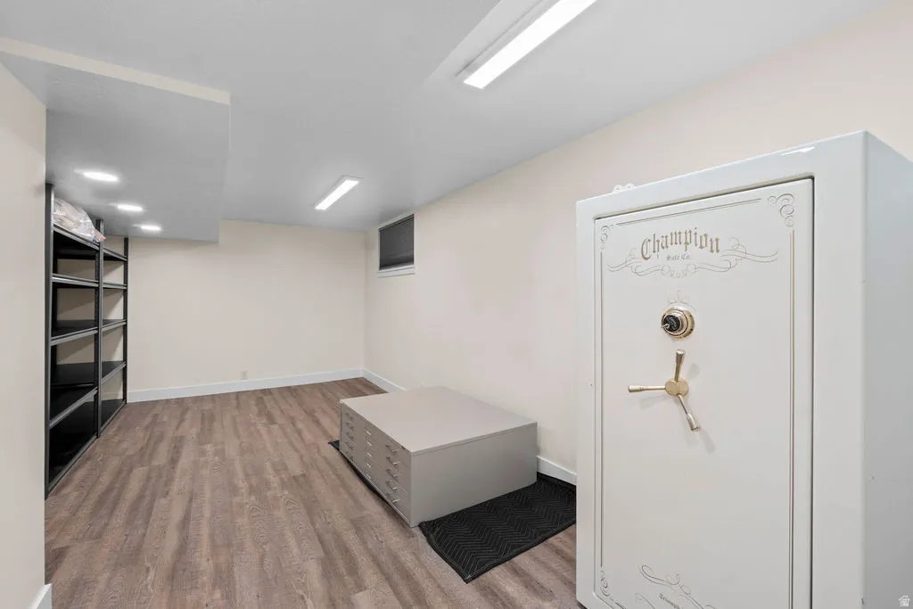 Versatile lower-level space featuring wood-finish flooring, white baseboards, and neutral wall paint