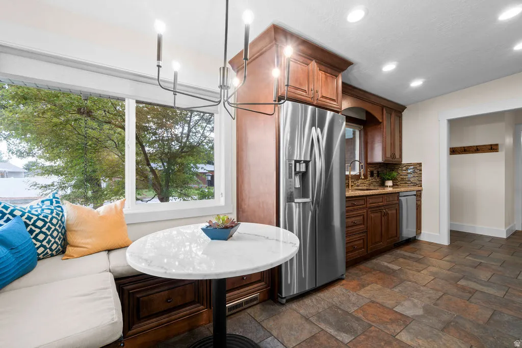 Kitchen featuring wood cabinetry, stainless steel appliances, and a tiled backsplash