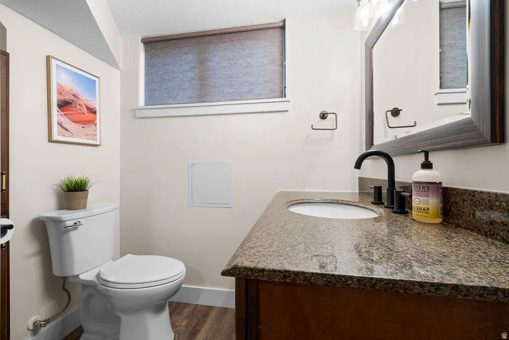 Vanity with a stone countertop, undermount sink, and matte black faucet