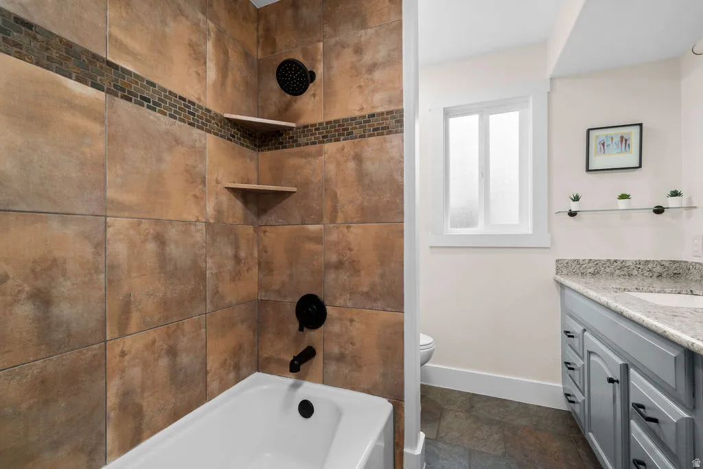 Bathroom featuring a shower-over-tub with large-format brown wall tiles, a decorative mosaic accent band, and matte black fixtures