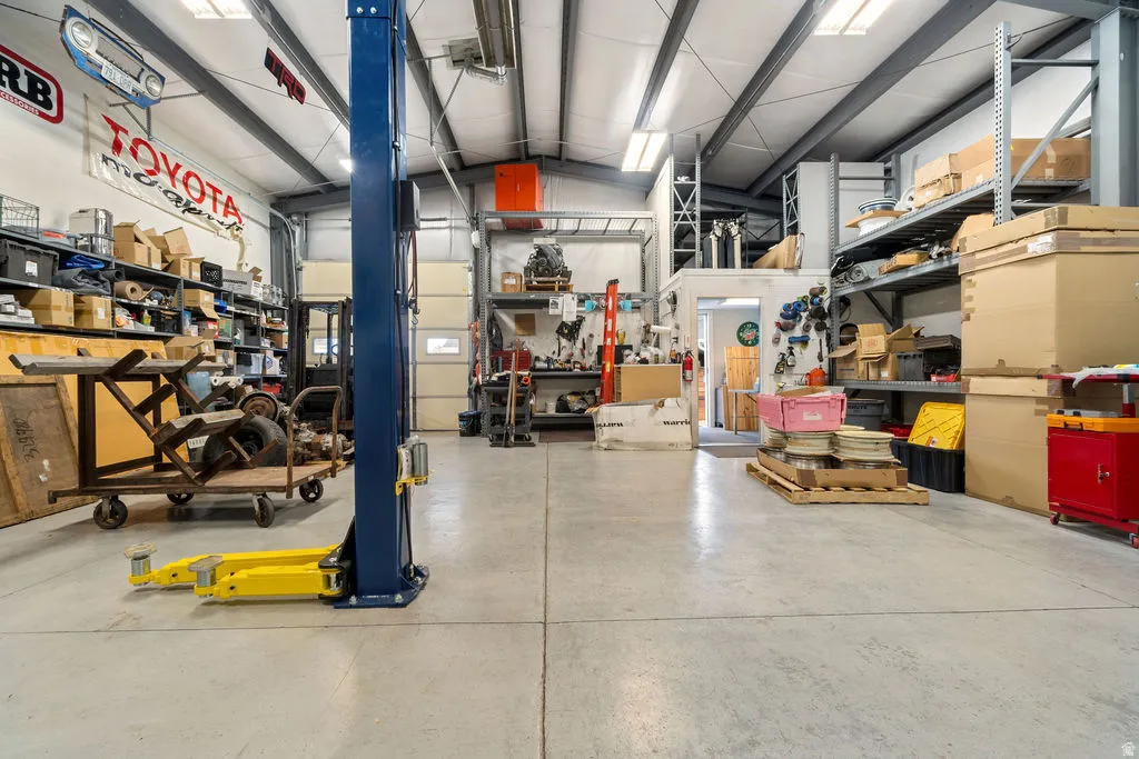 Spacious industrial-style interior featuring a high-bay ceiling, concrete flooring, and exposed structural beams