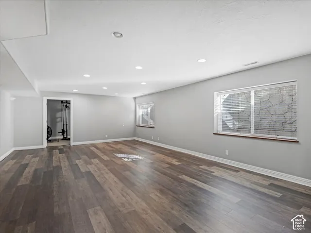 Spacious room featuring LVP flooring, recessed lighting, neutral wall tones, and white trim