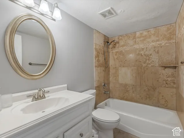 Downstairs Bathroom featuring a single vanity with an integrated sink, brushed nickel faucet, and an oval framed mirror