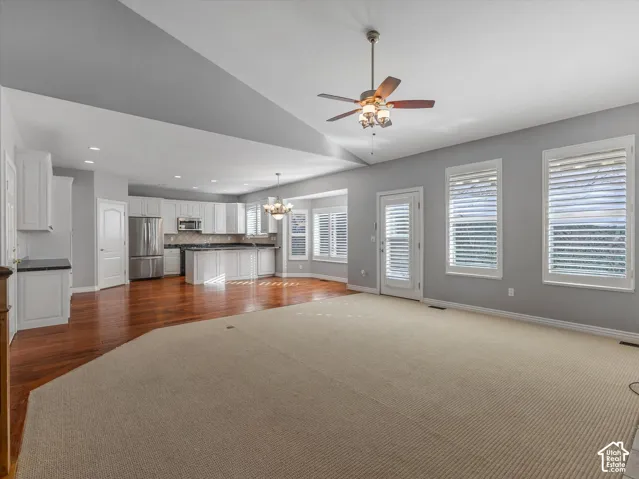 Open concept Spacious living area with vaulted ceiling and ceiling fan