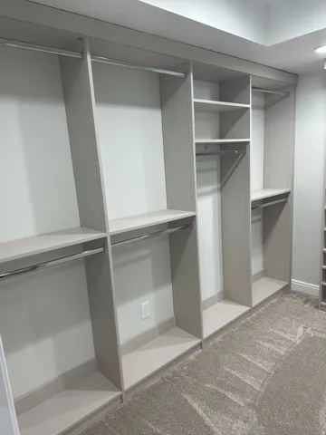 Custom closet system featuring multiple hanging rods and integrated shelving