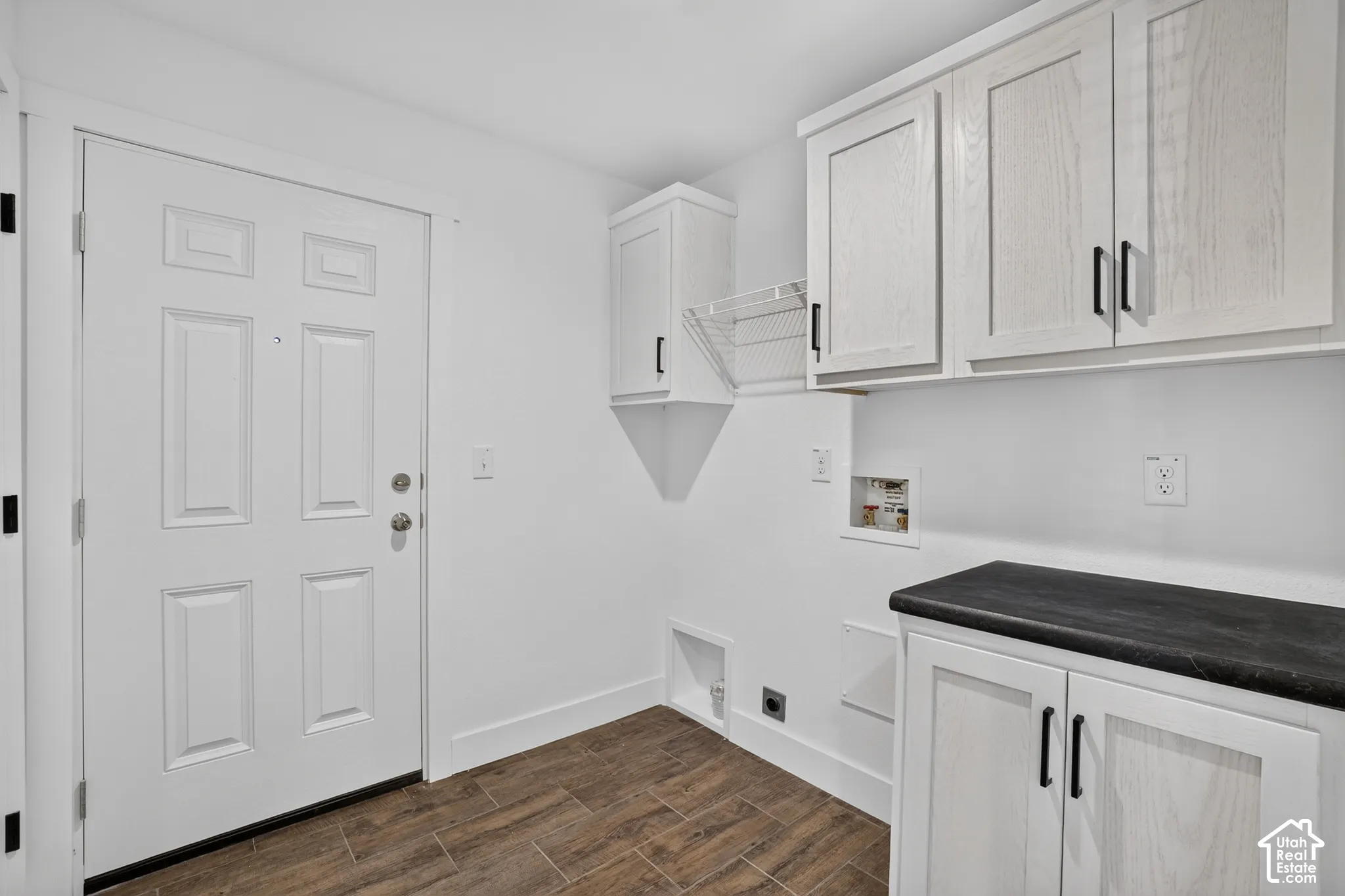 Utility room featuring wood-finish flooring and white walls