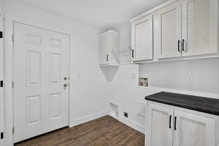 Utility room featuring wood-finish flooring and white walls
