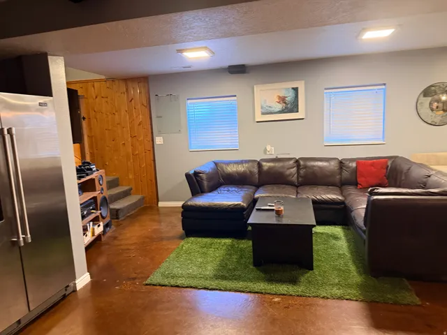 Spacious living area featuring polished concrete flooring and light blue-gray walls