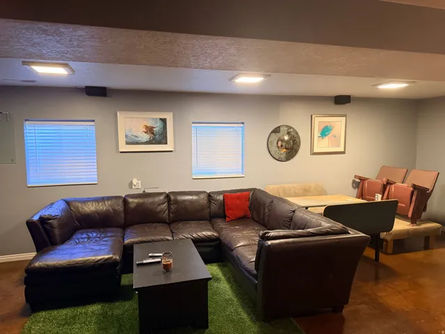 Spacious room featuring multiple window openings with blinds, flush-mount ceiling lighting, and hard-surface flooring