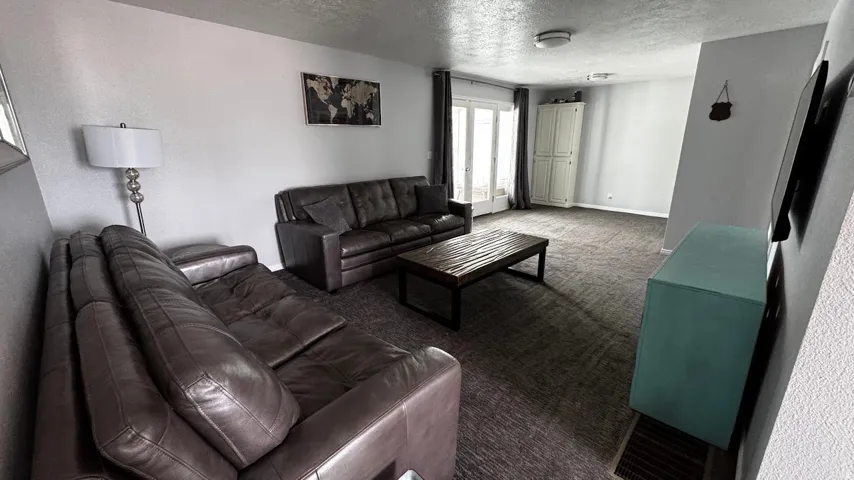 Spacious living area featuring neutral carpeting and light-toned walls