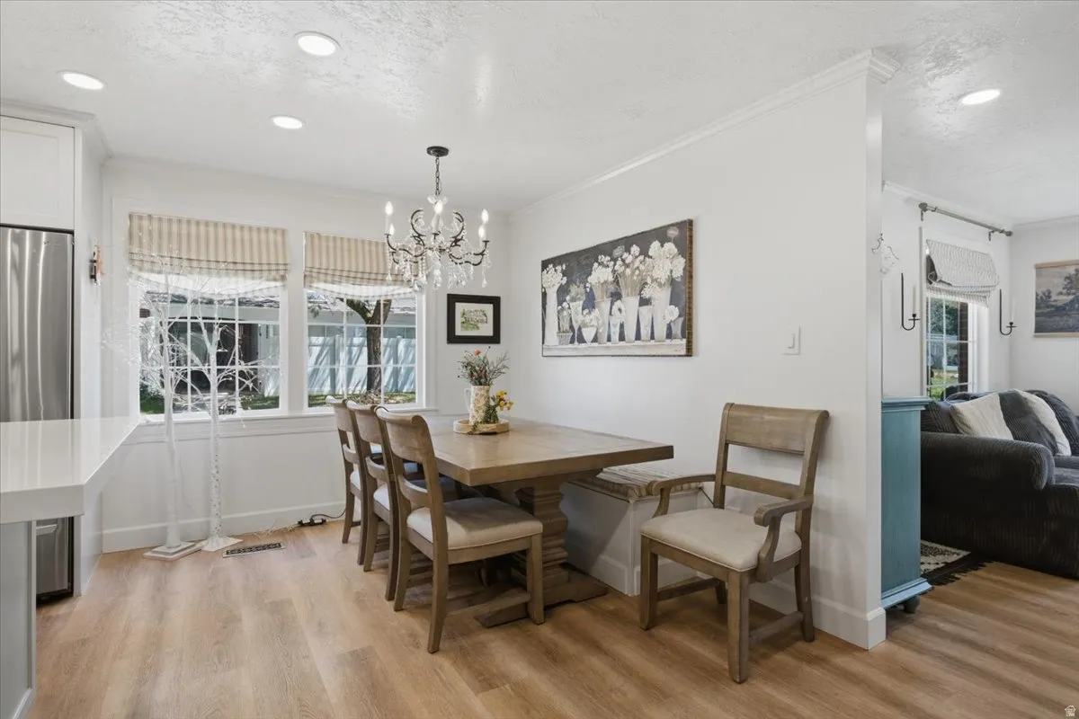 Dining area featuring wood-finish flooring, a chandelier, recessed lighting, and multiple windows