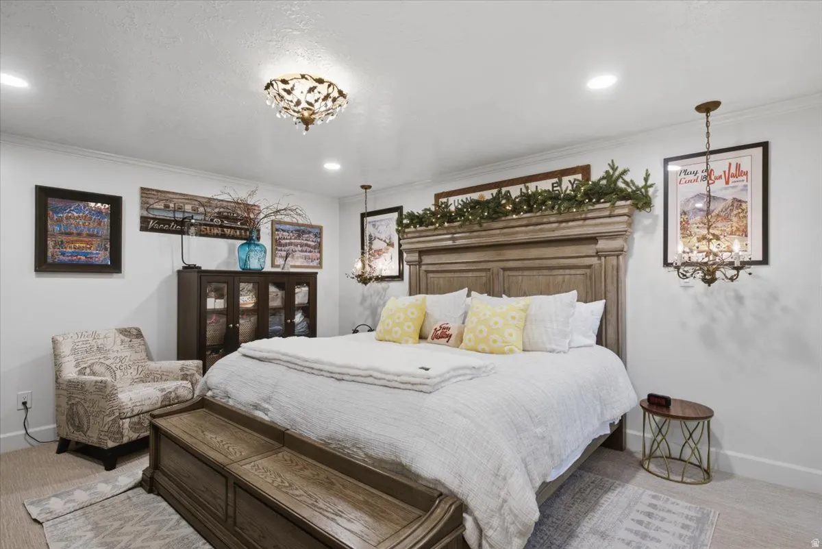 Bedroom featuring a large light wood-finish bed frame, recessed lighting, and crown molding
