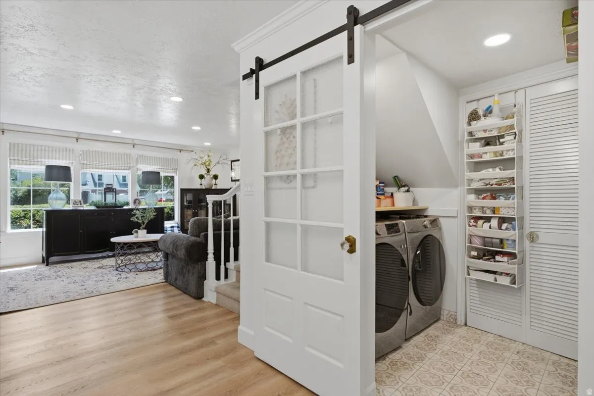 Dedicated laundry area featuring a patterned tile floor, built-in shelving, and louvered doors