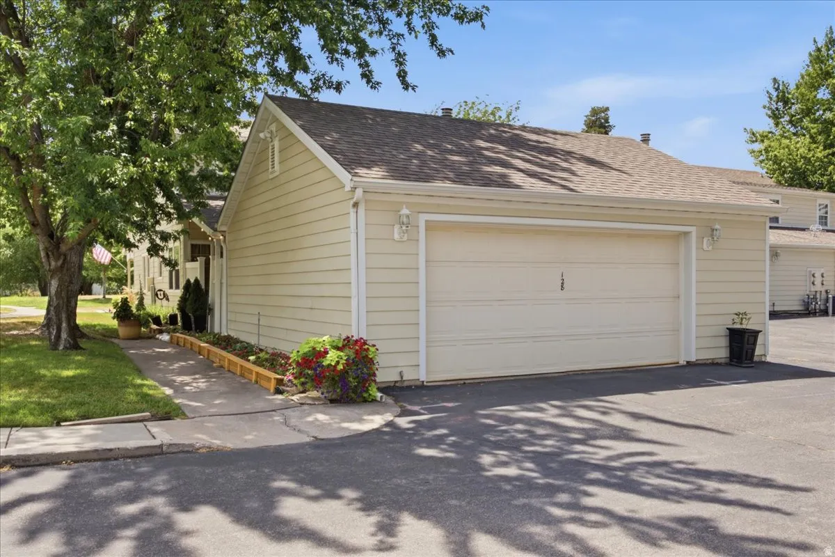 Attached garage featuring a light-colored sectional door, horizontal siding, and twin exterior wall sconces