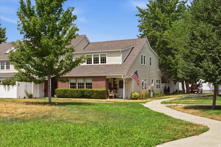 Two-story property featuring light-colored siding and brick accents