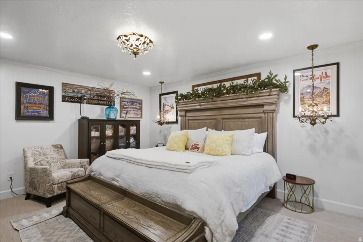 Bedroom featuring a large light wood-finish bed frame, recessed lighting, and crown molding