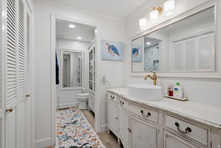 White vanity with a vessel sink and brass-finish faucet