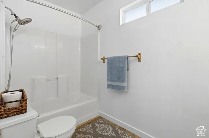 Full-height tub and shower surround, adjustable metallic shower head, and horizontal transom window