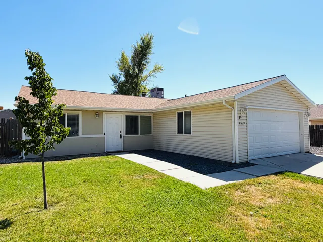 Ranch-style exterior featuring a two-car garage, light-colored siding, and a contrasting brown shingle roof