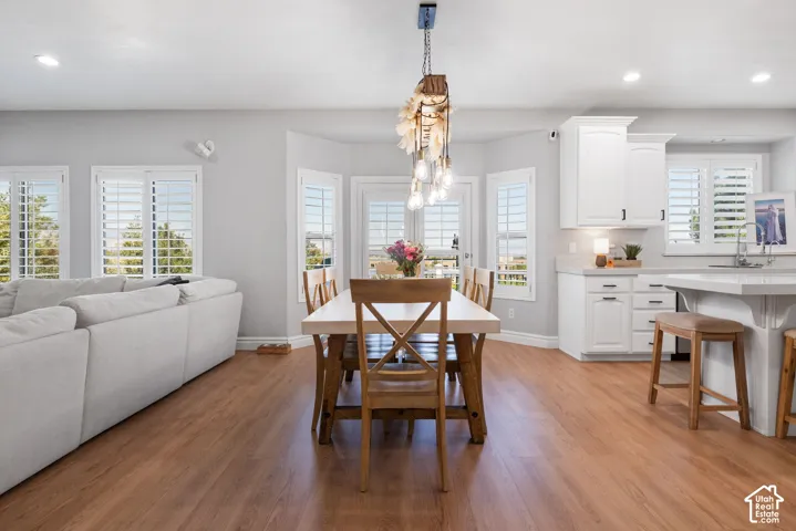 Open-concept living area featuring wood-finish flooring, white plantation shutters, and a bay window