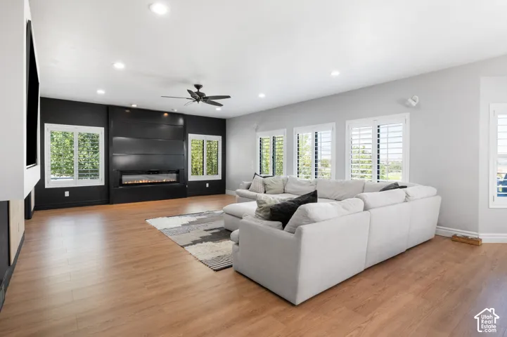Spacious living area featuring wood-finish flooring and a contemporary linear fireplace