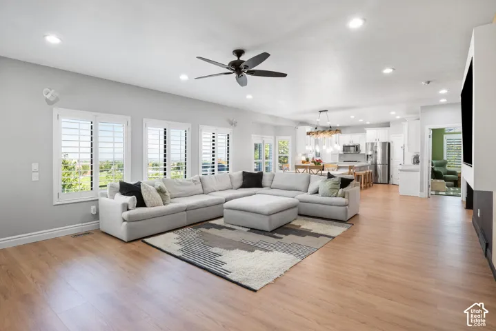 Open-concept living area featuring wood-finish flooring, recessed lighting, and a ceiling fan