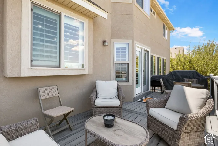 Spacious outdoor deck featuring composite decking, a stucco exterior, and multi-pane windows