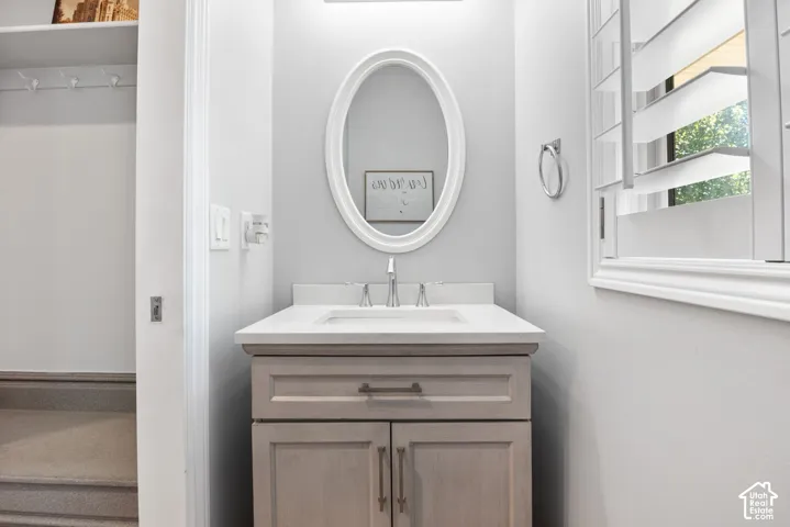 Vanity with a light wood-finish cabinet and a white countertop